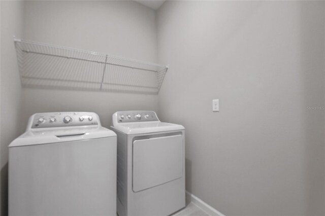 clothes washing area with washing machine and dryer