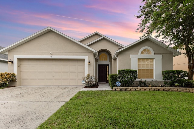 ranch-style home featuring a garage and a lawn