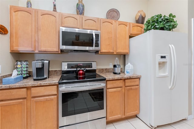 kitchen featuring light tile patterned floors, light brown cabinets, and appliances with stainless steel finishes