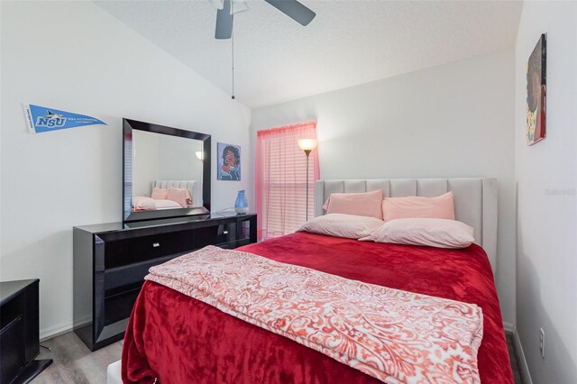 bedroom featuring ceiling fan, lofted ceiling, a textured ceiling, and light wood-type flooring