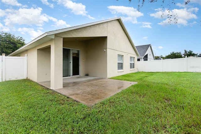 rear view of property featuring a yard and a patio area