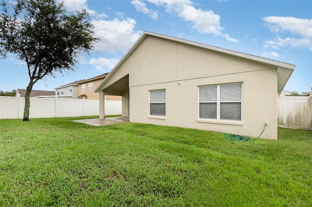 rear view of house with a patio area and a lawn