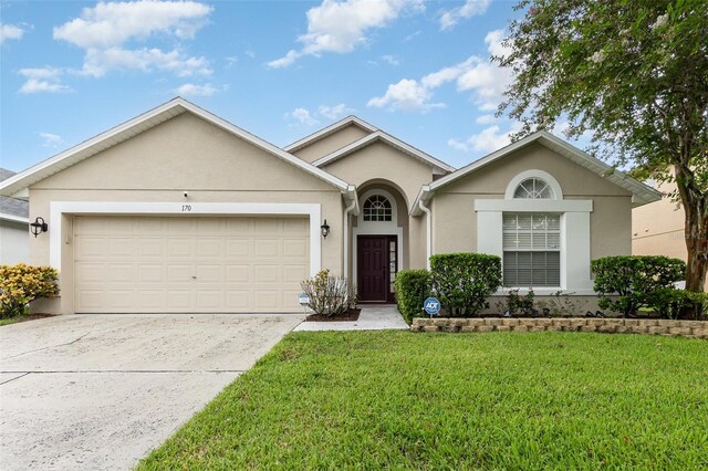 ranch-style house with a garage and a front lawn