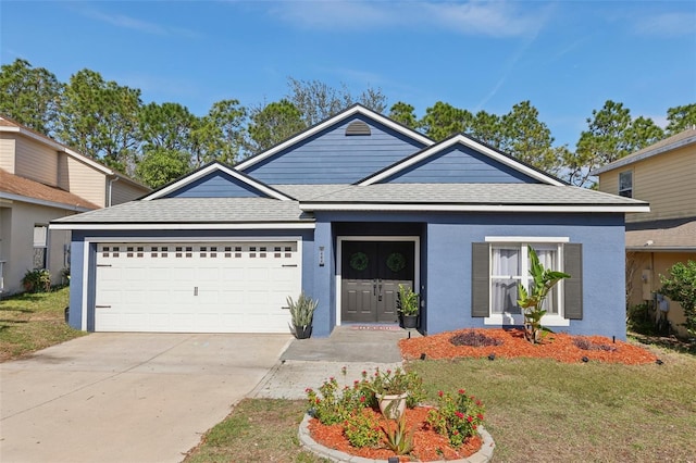 view of front of house featuring a garage and a front lawn