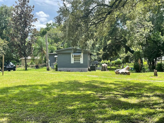 view of yard featuring central AC unit and fence