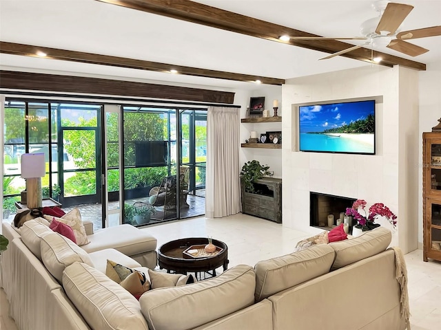 living area featuring a ceiling fan, beam ceiling, and a tiled fireplace