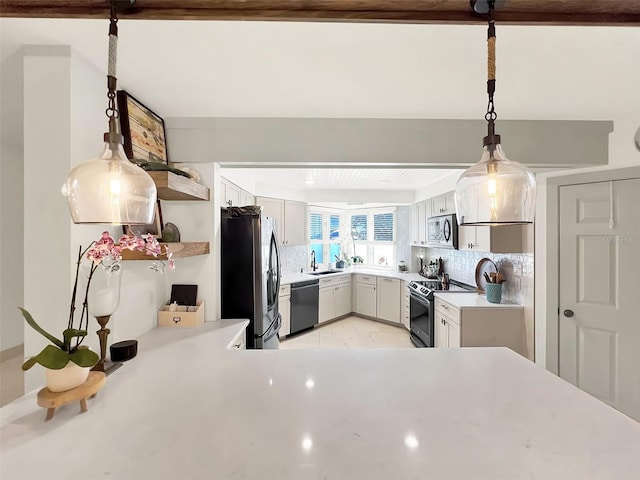 kitchen featuring backsplash, stainless steel appliances, light countertops, open shelves, and a sink