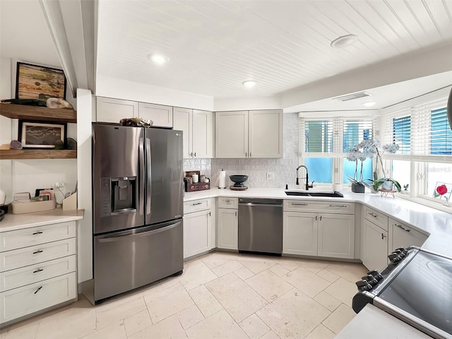 kitchen featuring visible vents, decorative backsplash, appliances with stainless steel finishes, light countertops, and a sink