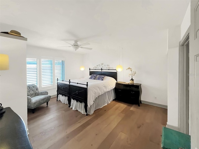 bedroom featuring ceiling fan, baseboards, and wood finished floors