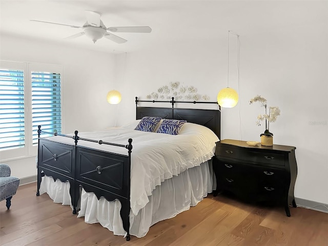 bedroom featuring light wood-type flooring, baseboards, and a ceiling fan