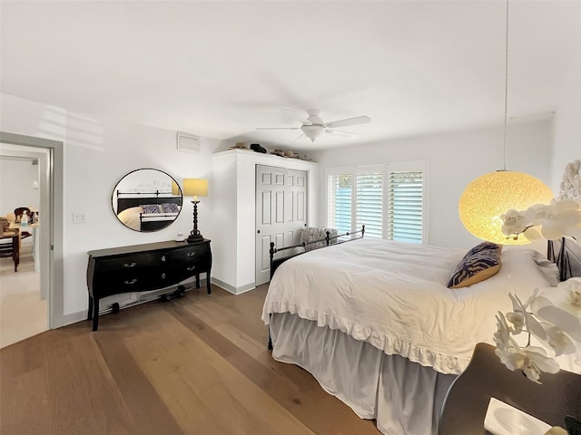 bedroom featuring ceiling fan, a closet, wood finished floors, and visible vents