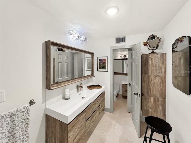 bathroom with visible vents, vanity, and toilet