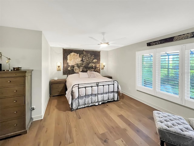 bedroom featuring ceiling fan, light wood-style flooring, and baseboards