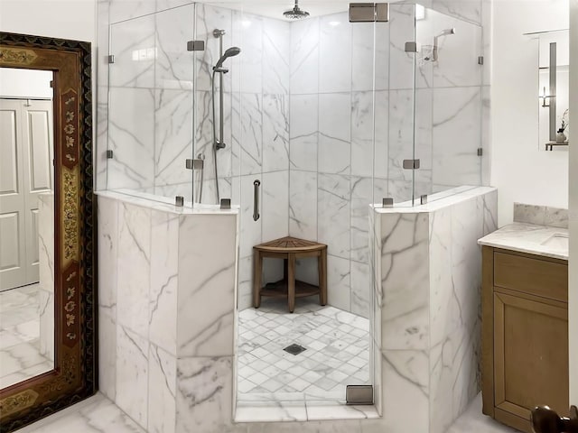 full bath featuring marble finish floor, vanity, and a marble finish shower