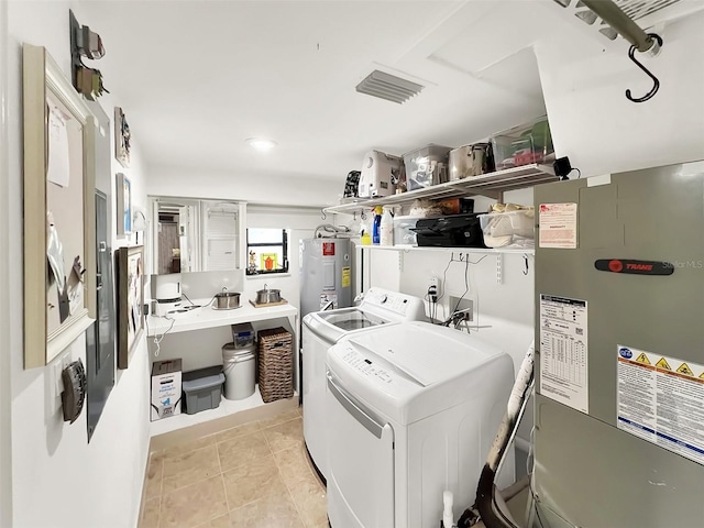 laundry room with light tile patterned floors, laundry area, washing machine and clothes dryer, and electric water heater