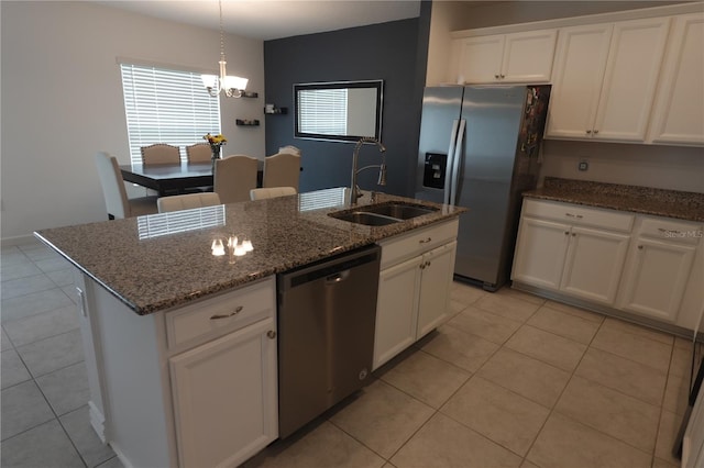 kitchen featuring light tile patterned flooring, sink, appliances with stainless steel finishes, a center island with sink, and white cabinets