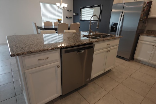 kitchen featuring an island with sink, white cabinets, appliances with stainless steel finishes, light tile patterned floors, and sink