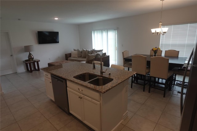 kitchen with sink, light stone counters, dishwasher, light tile patterned floors, and pendant lighting