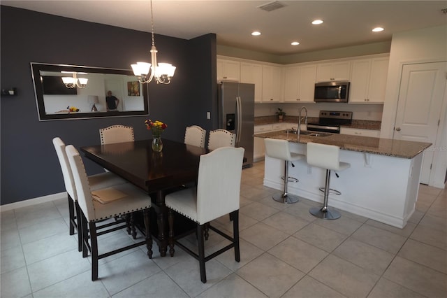 tiled dining space featuring sink and a notable chandelier