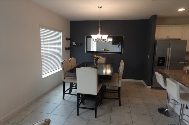 tiled dining space with a chandelier