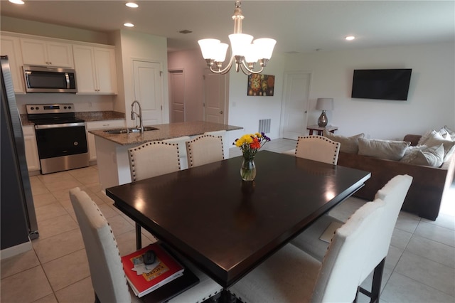 tiled dining room with sink and an inviting chandelier