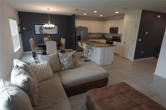 tiled living room with sink and a chandelier