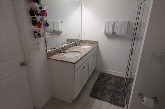 bathroom with an enclosed shower, double vanity, and tile patterned flooring