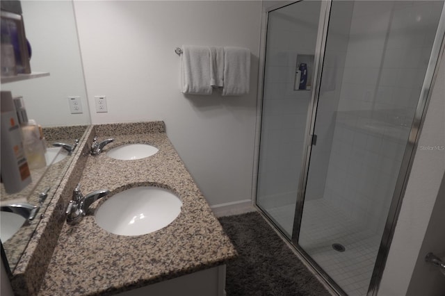 bathroom featuring an enclosed shower and dual bowl vanity