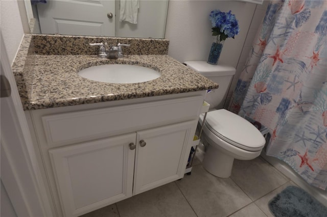 bathroom with tile patterned flooring, vanity, and toilet