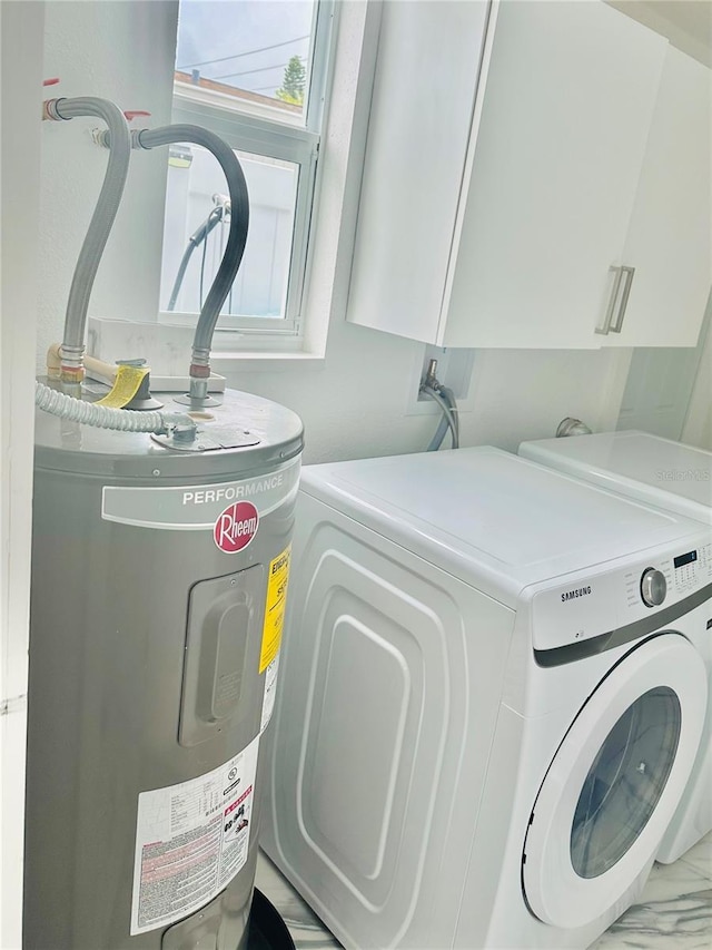 washroom with water heater, cabinets, and washer and dryer