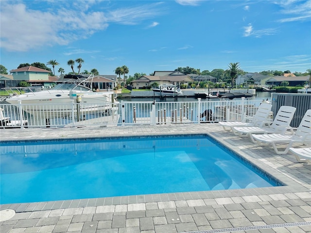 view of swimming pool featuring a patio area and a water view