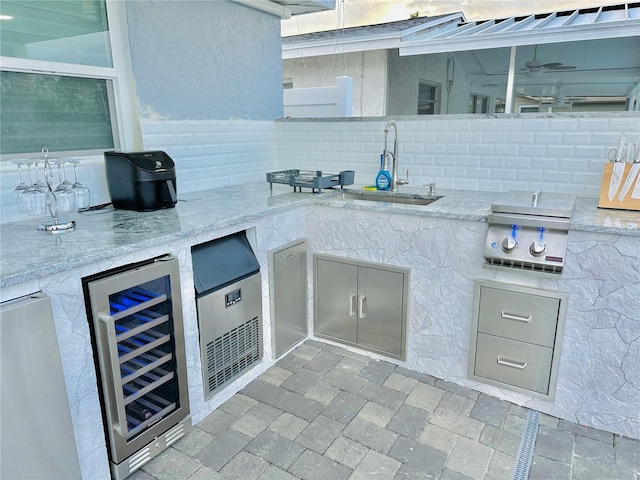 view of patio with wine cooler, area for grilling, a grill, and sink