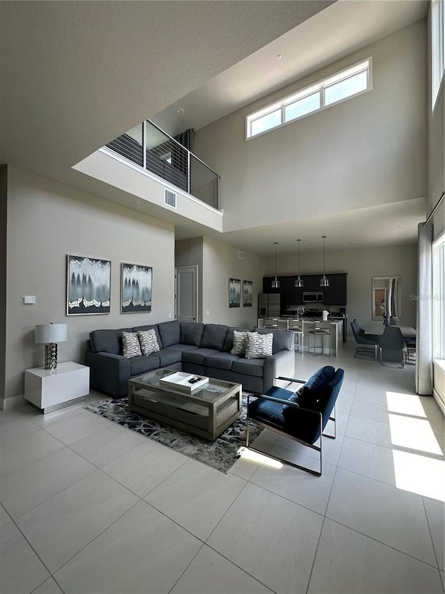 living room with tile patterned floors and a high ceiling