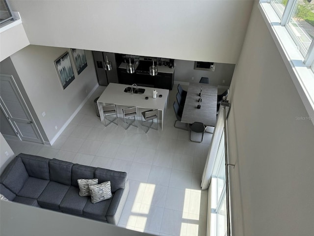 tiled living room with sink and a high ceiling