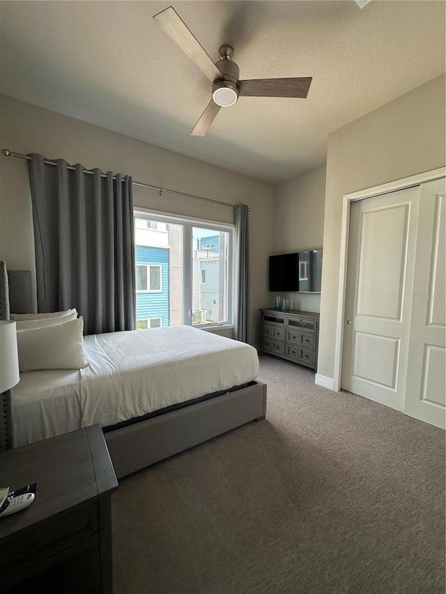 carpeted bedroom featuring a textured ceiling, ceiling fan, and a closet