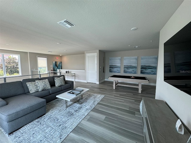 living room with a textured ceiling, hardwood / wood-style flooring, and pool table