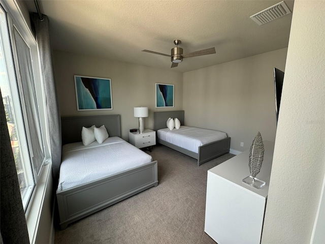 bedroom with a textured ceiling, carpet, and ceiling fan