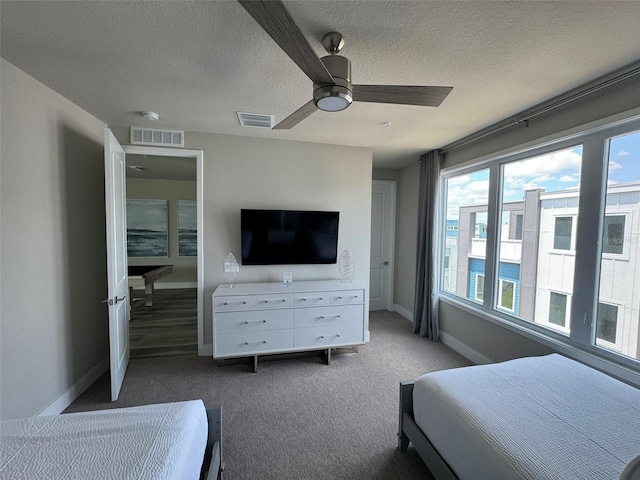 carpeted bedroom featuring a textured ceiling and ceiling fan