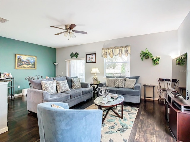 living area with ceiling fan, dark wood-type flooring, visible vents, and baseboards