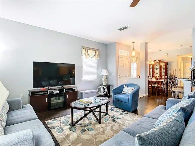 living room featuring a ceiling fan, visible vents, and wood finished floors