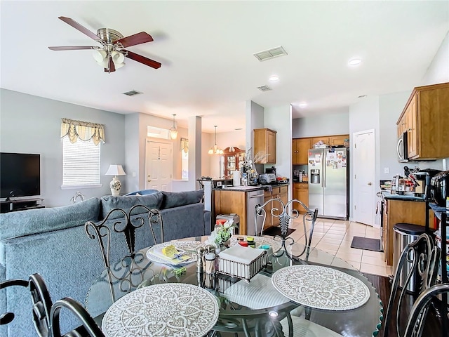 dining space with ceiling fan, visible vents, and light tile patterned flooring