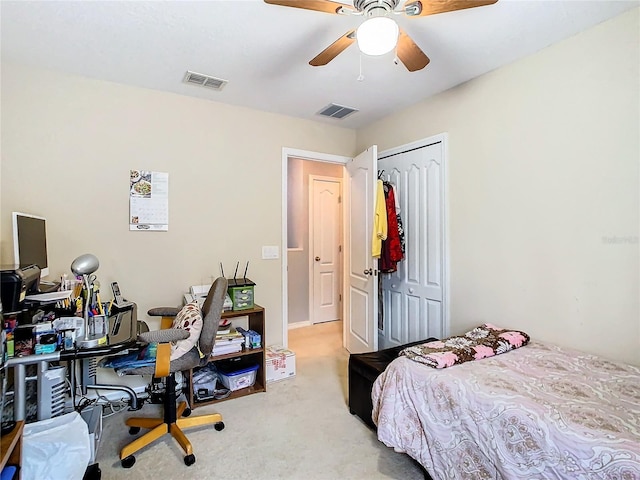 bedroom featuring ceiling fan, a closet, visible vents, and light colored carpet