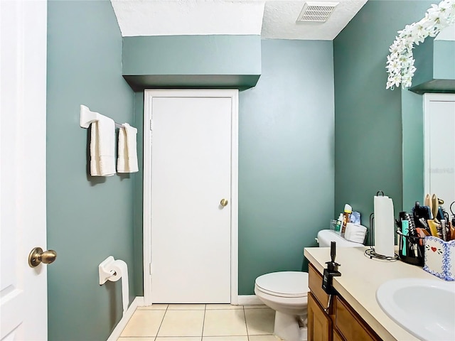 bathroom with visible vents, toilet, vanity, a textured ceiling, and tile patterned flooring