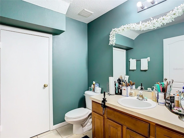 bathroom featuring a textured ceiling, tile patterned flooring, toilet, vanity, and visible vents