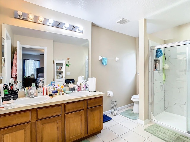 ensuite bathroom featuring a marble finish shower, visible vents, connected bathroom, and a sink