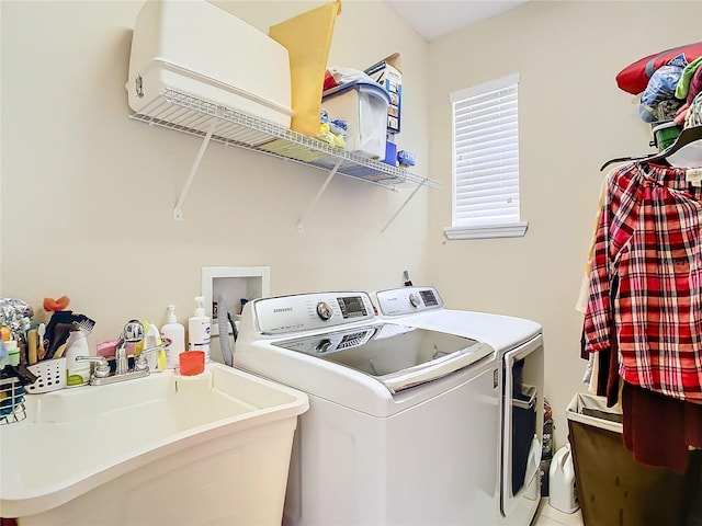 laundry area with laundry area, independent washer and dryer, and a sink