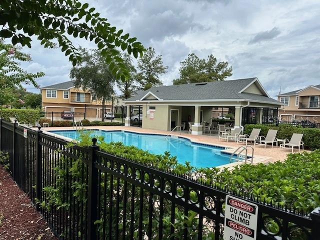 pool featuring fence and a patio