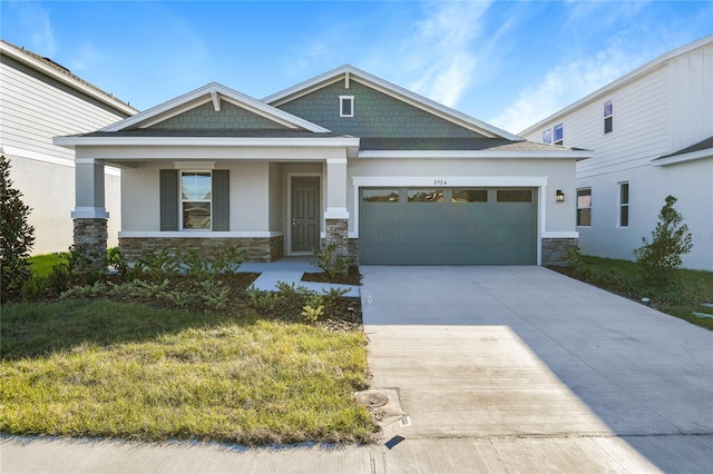 craftsman house with a front yard, a porch, and a garage