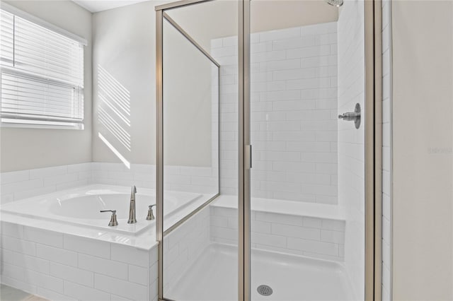 bathroom featuring shower with separate bathtub