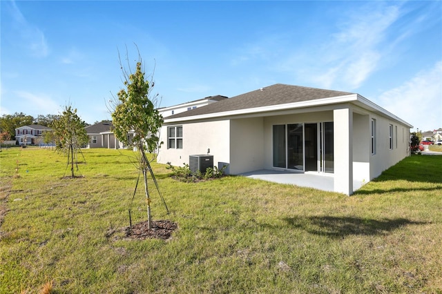 rear view of house with a lawn, a patio, and central AC unit